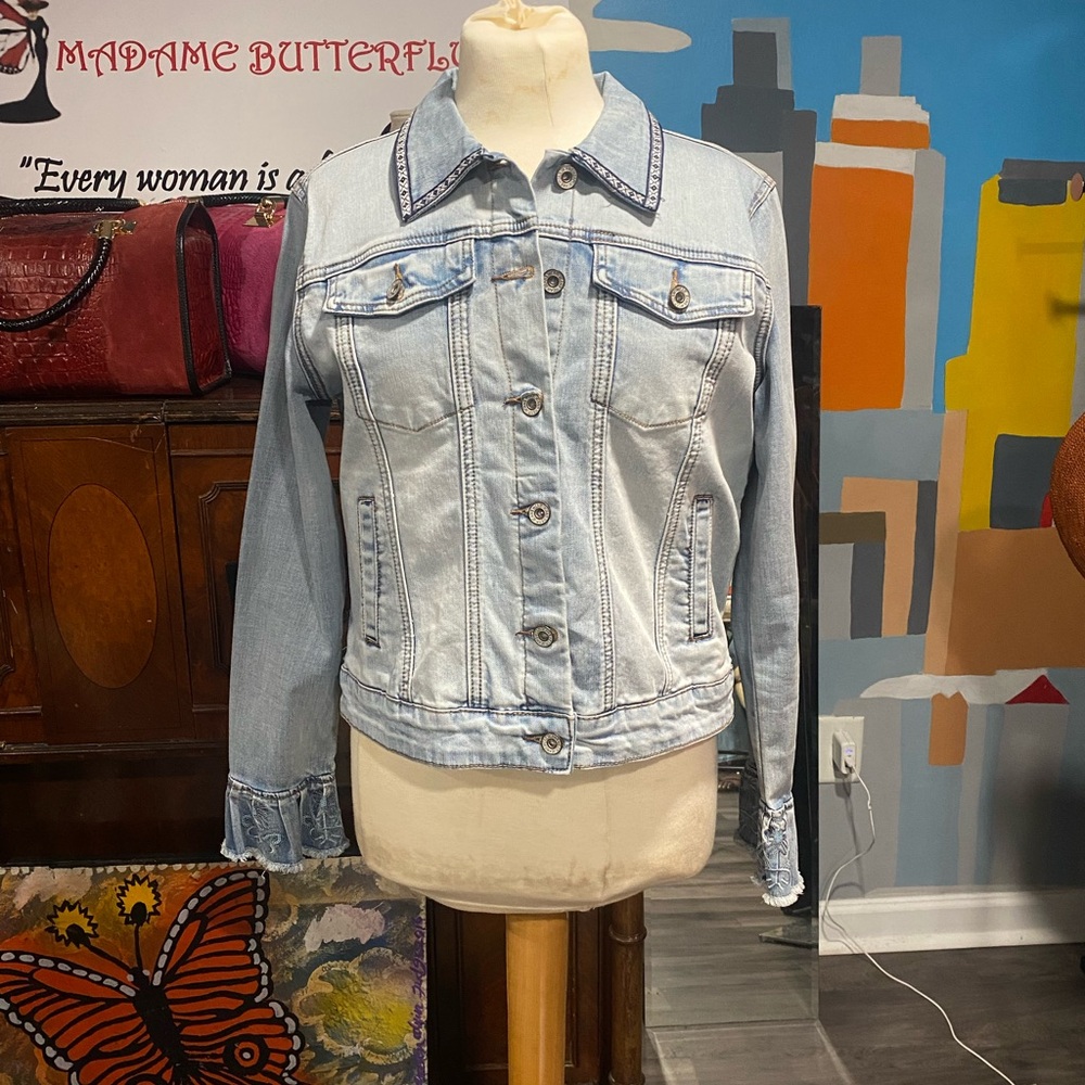 A denim jacket with embellishments on the back with pearls